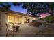 Backyard patio with comfortable seating, shade umbrella, and views of the desert landscape at dusk at 19403 E Apricot Ln, Queen Creek, AZ 85142