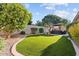 Well-maintained backyard features artificial turf, desert landscaping, and outdoor seating under an umbrella at 19403 E Apricot Ln, Queen Creek, AZ 85142