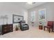 A welcoming bedroom is styled with a comfy armchair, shutters, and decorative accents at 19403 E Apricot Ln, Queen Creek, AZ 85142