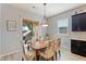 Bright dining area featuring a sliding glass door to the patio and a wooden table with floral upholstered chairs at 19403 E Apricot Ln, Queen Creek, AZ 85142