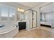 Bright main bathroom with a soaking tub, walk-in shower, and black framed shower door at 19403 E Apricot Ln, Queen Creek, AZ 85142