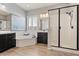Elegant main bathroom with a soaking tub, a glass-enclosed shower, and wood-look tile flooring at 19403 E Apricot Ln, Queen Creek, AZ 85142
