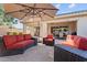 Relaxing outdoor patio featuring comfortable seating under a large umbrella with sliding glass door access to the house at 19403 E Apricot Ln, Queen Creek, AZ 85142