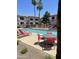 Relaxing pool area with lounge chairs, patio furniture, palm trees, and community condos at 1941 S Pierpont Dr # 2062, Mesa, AZ 85206
