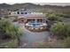 Desert home aerial view featuring a pool, hot tub, covered patio, and scenic desert landscaping at 1943 E Paso Nuevo Dr, Phoenix, AZ 85086