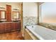 Bright bathroom features a soaking tub, dual sinks, and natural stone accents at 1943 E Paso Nuevo Dr, Phoenix, AZ 85086