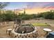 Desert backyard featuring a stone fire pit, seating area, and green accents at 1943 E Paso Nuevo Dr, Phoenix, AZ 85086