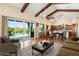 Spacious living room with patio access, beamed ceilings, and open layout to the dining area at 1943 E Paso Nuevo Dr, Phoenix, AZ 85086
