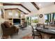 Open living room featuring beamed ceilings, a fireplace, and sliding glass doors to outdoor space at 1943 E Paso Nuevo Dr, Phoenix, AZ 85086