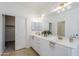 Elegant bathroom with double vanity, framed mirrors, modern lighting, and a sliding door closet at 2755 N 103Rd Ave, Avondale, AZ 85392