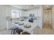 Bright white kitchen featuring stainless appliances, tiled backsplash, and bar stool seating at the island at 2755 N 103Rd Ave, Avondale, AZ 85392