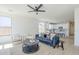 Bright living room showcases a plush blue sofa, tile flooring, and an open layout to the kitchen at 2755 N 103Rd Ave, Avondale, AZ 85392