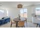 Bright living room with tile floors includes a woven light, kitchen, and a comfortable blue sofa at 2755 N 103Rd Ave, Avondale, AZ 85392