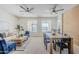 Open-concept living and dining area with large windows, modern ceiling fans, and stylish furniture at 2755 N 103Rd Ave, Avondale, AZ 85392