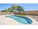 Backyard in-ground pool features synthetic grass, rock landscape, and a decorative retaining wall at 2755 N 103Rd Ave, Avondale, AZ 85392