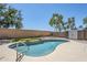 Backyard in-ground pool features synthetic grass, rock landscape, mature trees, and a storage shed at 2755 N 103Rd Ave, Avondale, AZ 85392