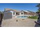 Backyard in-ground pool features synthetic grass, rock landscape, storage shed and home exterior at 2755 N 103Rd Ave, Avondale, AZ 85392