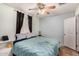 A well lit bedroom features a ceiling fan, window with curtains and side table at 2802 E Virginia Ave, Phoenix, AZ 85008