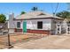 Charming white home with red brick accents and a bright turquoise front door at 2802 E Virginia Ave, Phoenix, AZ 85008