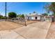Charming white home with red brick accents and a bright turquoise front door and chain-link fence at 2802 E Virginia Ave, Phoenix, AZ 85008