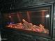 Modern fireplace with decorative black tiling, logs, and electric embers at 28349 N 113Th St, Scottsdale, AZ 85262