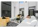 Open-concept living area with a stylish fireplace, comfortable seating, and a view of a modern kitchen and wine fridge at 28349 N 113Th St, Scottsdale, AZ 85262