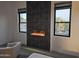 Bedroom featuring an electric fireplace with decorative tiling and desert views from the two windows at 28349 N 113Th St, Scottsdale, AZ 85262