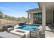 Outdoor living area features a pool with a waterfall, built-in grill, and comfortable seating at 28349 N 113Th St, Scottsdale, AZ 85262
