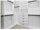 Well-organized walk-in closet with white shelving, drawers, and black hanging rods for clothing storage at 28349 N 113Th St, Scottsdale, AZ 85262
