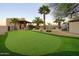 Expansive backyard featuring a putting green, desert plants, and manicured landscaping at 31721 N 138Th Pl, Scottsdale, AZ 85262