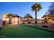 Lush backyard features a putting green, palm trees, desert plants and a cozy patio at 31721 N 138Th Pl, Scottsdale, AZ 85262
