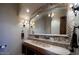 Unique bathroom featuring an elongated stone sink, a stone-trimmed mirror, and decorative lighting at 31721 N 138Th Pl, Scottsdale, AZ 85262