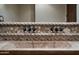 Detailed view of the stone bathroom sink with decorative tile work and antique style faucets at 31721 N 138Th Pl, Scottsdale, AZ 85262
