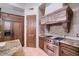 Gourmet kitchen featuring stone countertops, a stainless steel range hood, and custom wooden cabinetry at 31721 N 138Th Pl, Scottsdale, AZ 85262