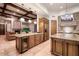Open kitchen boasts wooden cabinets, coffered ceilings, and island seating, leading to the adjacent living area at 31721 N 138Th Pl, Scottsdale, AZ 85262