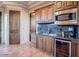 A wet bar features wooden cabinets, counter space, and stainless steel appliances at 31721 N 138Th Pl, Scottsdale, AZ 85262