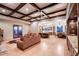 Open-concept living room boasts coffered ceilings, tile floors, a comfortable sofa, and seamless access to the kitchen at 31721 N 138Th Pl, Scottsdale, AZ 85262