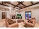 Cozy living room featuring a stone fireplace, comfortable seating, coffered ceilings, and access to a backyard patio at 31721 N 138Th Pl, Scottsdale, AZ 85262