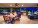 Relaxing outdoor dining area with seating, fireplace, ceiling fans and lush landscaping at 31721 N 138Th Pl, Scottsdale, AZ 85262