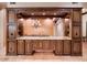 Custom wet bar area featuring dark wood cabinetry, granite countertops, and space for entertaining with a chandelier at 31721 N 138Th Pl, Scottsdale, AZ 85262