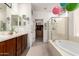 Bathroom with dual sinks, tub and walk-in shower, with access to walk in closet at 41227 N Rolling Green Way, Anthem, AZ 85086