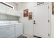 Convenient laundry room with washer, dryer, overhead cabinets and exterior door at 41227 N Rolling Green Way, Anthem, AZ 85086