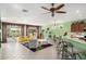 Bright open-concept living room features a ceiling fan and large windows overlooking the backyard at 41227 N Rolling Green Way, Anthem, AZ 85086