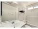 Bright bathroom showcases a vanity and a bathtub with shower head at 41251 W Cahill Dr, Maricopa, AZ 85138