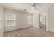 Bright bedroom features neutral carpeting and two windows with blinds at 41251 W Cahill Dr, Maricopa, AZ 85138