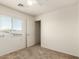 Bedroom featuring neutral carpeting, a bright window, and closet access at 41251 W Cahill Dr, Maricopa, AZ 85138