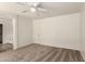 Bright bedroom features neutral carpeting, a ceiling fan, and en-suite bathroom at 41251 W Cahill Dr, Maricopa, AZ 85138