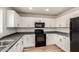 Bright kitchen with white cabinets, black appliances, light counters and ample cabinet space at 41251 W Cahill Dr, Maricopa, AZ 85138