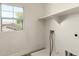 Bright laundry room with a window and a convenient shelf for storage, plus washer-dryer hookups at 41251 W Cahill Dr, Maricopa, AZ 85138