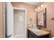 Bathroom featuring a single sink vanity, framed mirror and door to a small area at 4200 N Miller Rd # 408, Scottsdale, AZ 85251